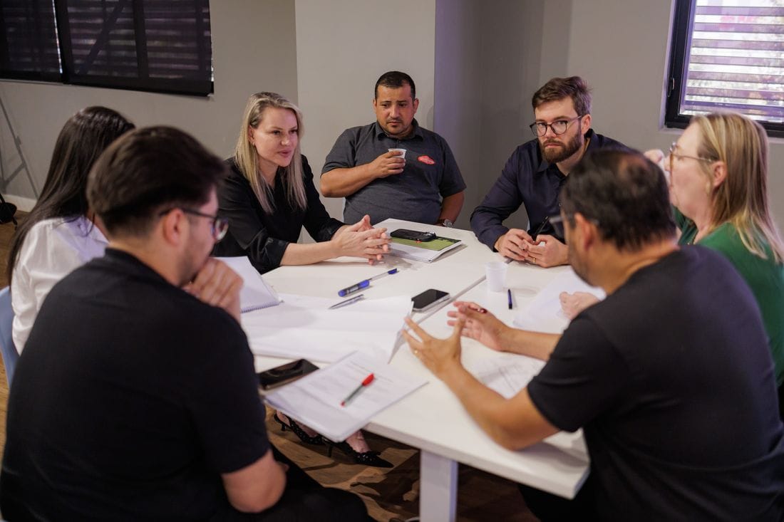 Sócios trabalhando em grupo ao redor da mesa na imersão